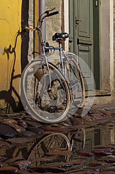 Vintage bike tied to the downpipe on cobbled street of old town