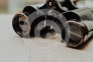 Vintage binoculars on a wooden background