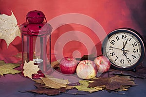 Vintage black alarm clock on autumn leaves. Time change abstract photo. Daylight saving time