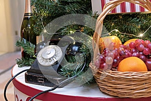 Vintage black telephone and fruit basket near the Christmas tree.