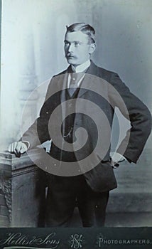 Vintage black and white photo of a young Victorian man with moustache wearing smart suit and big collar shirt 1880s - 1900s.