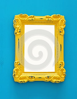 Vintage blank yellow photo frame over blue background. Ready for photography montage. Top view from above.