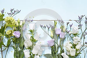 Vintage blue green wooden background with purple, lilac, white and yellow field flowers with empty copy space