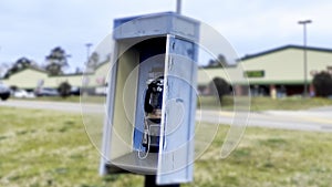 Vintage Blue outdoors public payphone booth side view blur effect