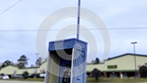 Vintage Blue outdoors public payphone booth top and traffic blurred