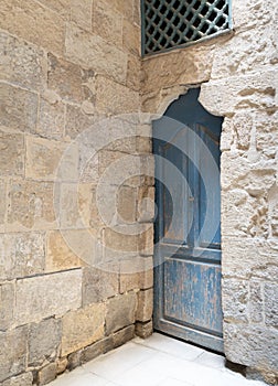 Vintage blue wooden closed door and stone bricks wall