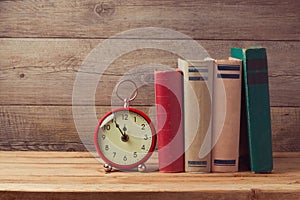 Vintage books and clock on wooden table