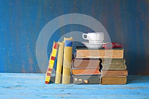 Vintage books with coffee cup and specs