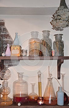 Vintage bottles with herbs on the shelf in an old pharmacy.