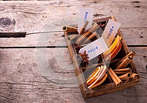 Vintage box with  different spices - cinnamone, slices of dried orange, anise on aged wooden  background. photo