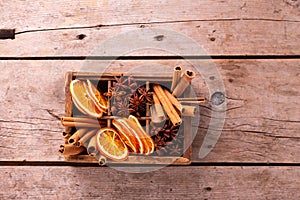Vintage box with spices - cinnamone, slices of dried orange, anise on vintage wooden  background. photo