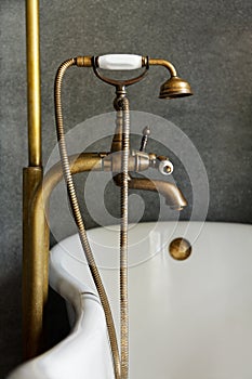 Vintage brass douche or faucet at bathtub