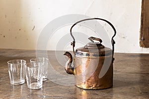 Vintage brass tea pot with empty glasses