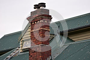 Vintage brick chimney on metal roof