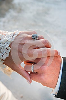 A vintage bride and groom rings on embracing hands after being married at a wedding