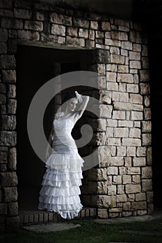 Vintage bride leaning against brick wall
