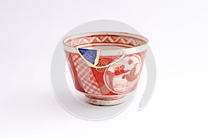 Vintage broken cup repaired with gold kintsugi technique photo