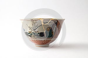 Vintage broken Japanese bowl repaired with gold kintsugi technique photo