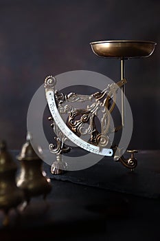 Vintage bronze or brass scales on a dark background. Postal vintage scales. Vintage items or antiques