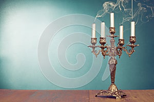 Vintage bronze candlestick with five reek candles in front mint blue background photo