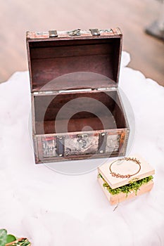 Vintage brown box for wedding wishes and little wooden box for wedding rings filled with green moss on the table