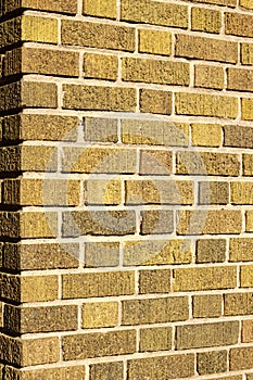 Vintage brown brick wall corner texture background with low angle sunlight