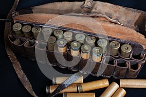 Vintage brown leather hunting bandolier with cartridges on black