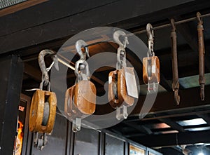 A vintage brown metal and wooden pulley block.