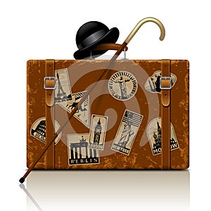 Vintage brown threadbare suitcase with walking stick, bowler hat photo