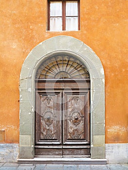 Vintage brown wood old door in the medieval sity of Pisa, Italy