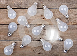 Vintage bulbs on wooden background - idea, innovation, teamwork and leadership concept. Space for text