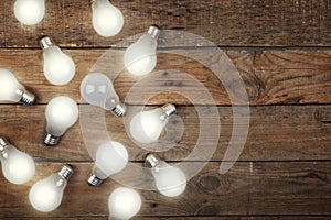 Vintage bulbs on wooden background - idea, innovation, teamwork and leadership concept. Space for text