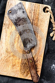 Vintage butcher meat cleaver on concrete board. Black background. Top view