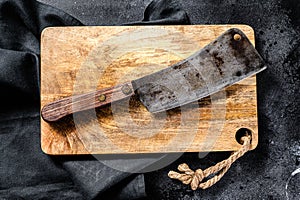 Vintage butcher meat cleaver on concrete board. Black background. Top view