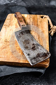 Vintage butcher meat cleaver on concrete board. Black background. Top view