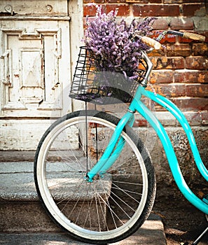 Vintage bycycle with basket with lavender flowers near the wooden door