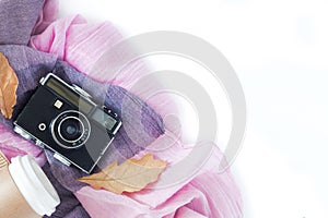 Vintage camera with coffee, autumn leaves and scarf on white background .