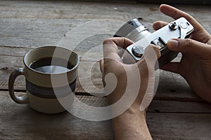 Vintage camera with coffee in old desk