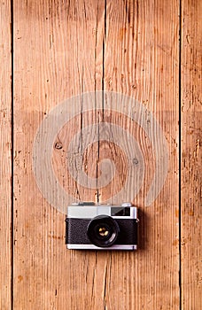 Vintage camera laid on table. Wooden background. Studio shot