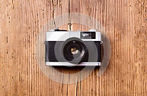 Vintage camera laid on table. Wooden background. Studio shot