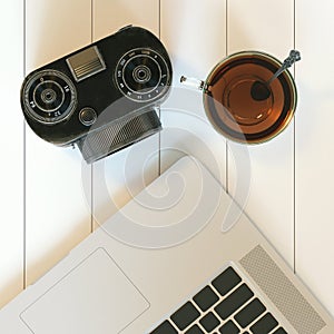 Vintage camera and laptop and glass cup of hot tea on white hard