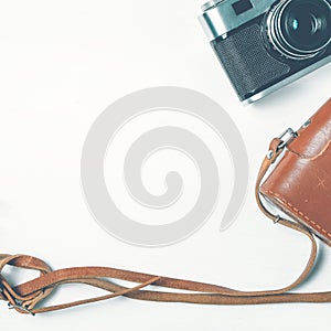 Vintage camera with leather case on a wooden white background. Copy space. square format, toned