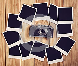 Vintage camera and many blank photo frames on wooden table. Top