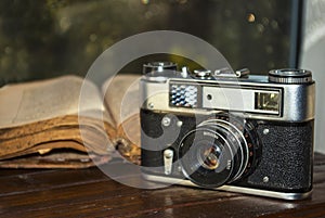Vintage camera and old book on table