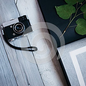 vintage camera, an old photo album on the white wooden table