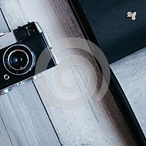 vintage camera, an old photo album on the white wooden table