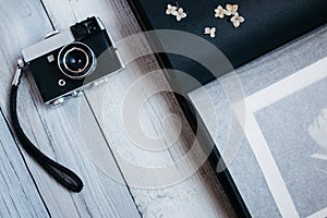 vintage camera, an old photo album on the white wooden table