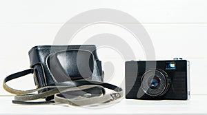 Vintage camera on the white wooden background. Concept of old technology. Photo with place for text.