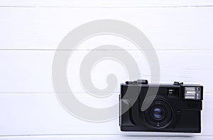 Vintage camera on white wooden background. Old photo camera on background