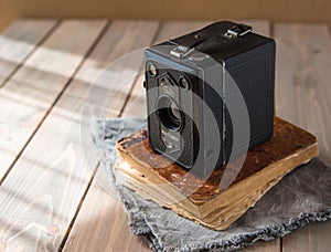 Vintage camera on wooden background and book